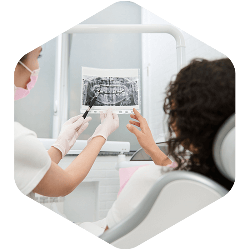 Woman with wisdom tooth pain and doctor's arms showing her a panoramic view of where the pain is located..